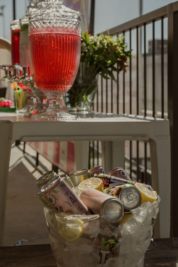 An outdoor beverage station featuring colorful drinks in a summer setting, perfect for events.